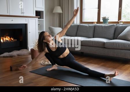 Young fit woman doing Side Lunge asana at home Stock Photo