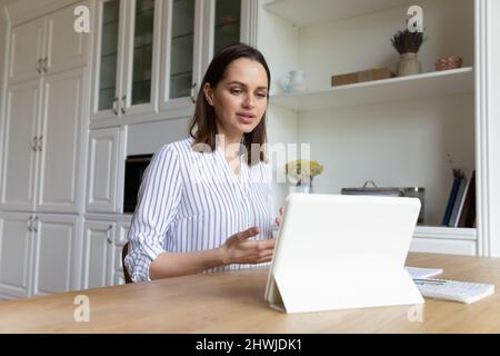 Woman use digital tablet talks on video conferencing application Stock Photo
