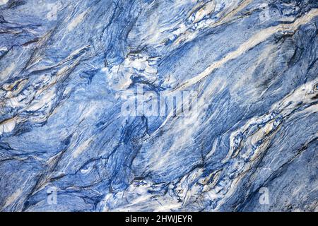Texture of natural blue quartz stone with black-white blotches. Stock Photo