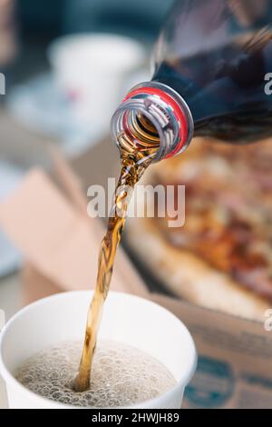 Pouring soda drink from bottle to glass, close up. Stock Photo