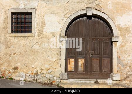 Facade of an old building with a large wooden entrance door Stock Photo