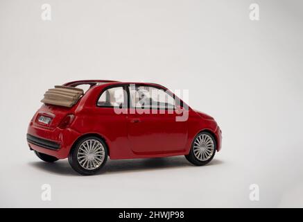 Rear and side view of a red  2 door cabriolet Fiat 500  metal model car to scale with fold back hood Stock Photo