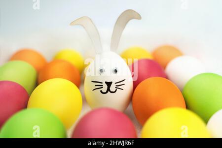 Funny bunny among colorful eggs. Holiday card. Easter background Stock Photo