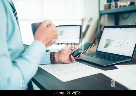 Businessman use cell phone and working on office desk and analyzing new project of accounting finance. Investment, Financial advisor and accounting co Stock Photo