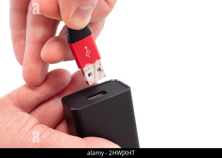 Hands connect the usb cable to the socket on a white background close-up. USB connection Stock Photo