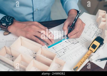 Architect engineer use pen and  ruler drawing design working and tape measure on bueprint. House planning design and construction concept. Stock Photo