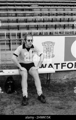 Elton John, just back from a tour of America, wants to be a director of Watford FC. He has always been a fan, and has just been made a vice president. Pictured at Watford to meet and train with the players to keep fit. Pictured, Elton John a bit puffed, relaxes during training. 7th November 1973. Stock Photo