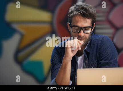Getting his head around the project. Shot of a male entrepreneur working at his desk. Stock Photo