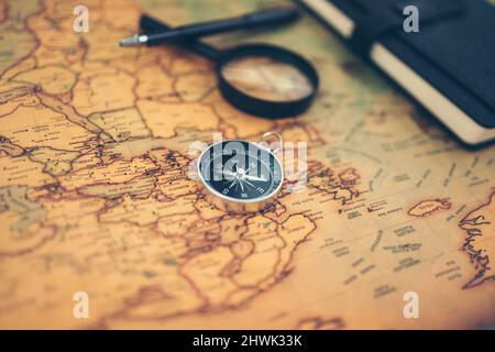 Magnetic compass, magnifying glass and diary on world map. Travel , Adventure and Discovery concept. Stock Photo