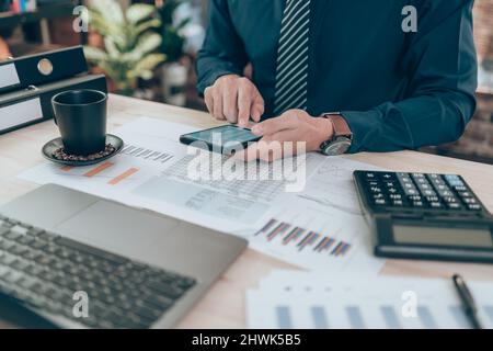 Businessman use cell phone and working on office desk and analyzing new project of accounting finance. Investment, Financial advisor and accounting co Stock Photo