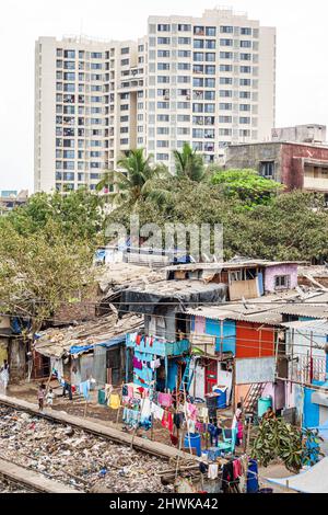 Mumbai India,Dharavi Shahu Nagar,slum shanties poor poverty lower Hindu caste,low income trash litter ghetto homes,modern high rise apartment building Stock Photo