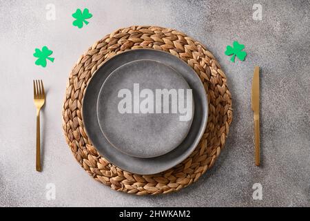 St Patrick's Day table setting with green decor on gray background. View from above. Copy space. Stock Photo