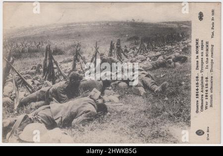 'War 1914-15-16... In the Somme. British offensive - Troops resting' / 'Guerre 1914-15-16... Dans la Somme. Offensive Anglaise - Troupes au repos'. French First World War postcard showing exhausted British soldiers on the Somme battlefield, with propped up rifles and tin helmets laid on the ground. Plumes of earth thrown up by shells can be seen on the horizon Stock Photo