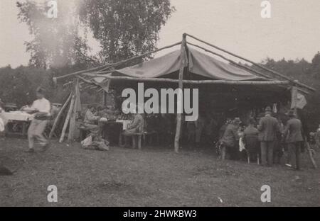 vintage black and white photo about an event or wedding in a tent, where the waiters or servers are wearing fez turkish hat. Or it is a big grill party.  Period: 1920s. Source: original photograph. ADDITIONAL-RIGHTS-CLEARANCE-INFO-NOT-AVAILABLE Stock Photo