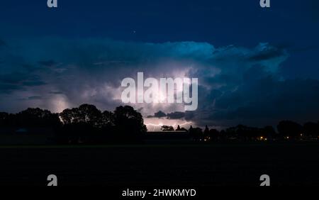 Silhouette of a landscape when lightning storm flashes in the sky of ...