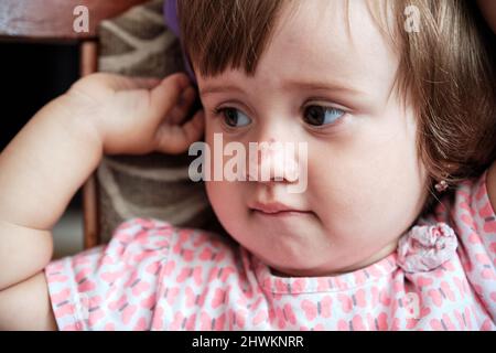 Portrait of a sad little girl with a scratched nose, close-up, selective focus. Child safety concept, injuries from falling down. Stock Photo