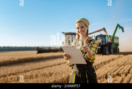 Farmer with clipboard on field keeping track of the grain harvest Stock Photo