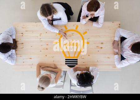 High angle view of business people at meeting table. Conceptual for bright business ideas and innovations. Stock Photo