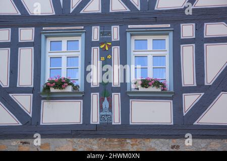 Decorative windows with flower pots, on half-timbered house, in Ortenberg in der Wetterau, Hesse, Germany Stock Photo