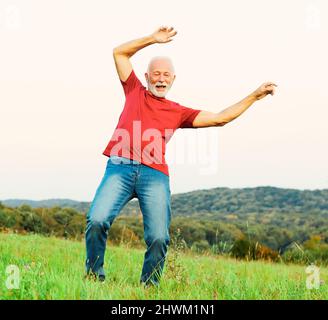 man outdoor senior happy lifestyle retirement dancing nature mature active elderly vitaliti training exercise stretching fitness Stock Photo