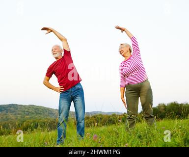 outdoor senior fitness woman man lifestyle active sport exercise healthy fit retirement stretching elderly couple Stock Photo