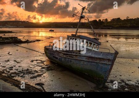 Appledore, North Devon, England. High tide on a tranquil but cold River Torridge estuary as the incoming tide covers long abandoned boats on the shore Stock Photo