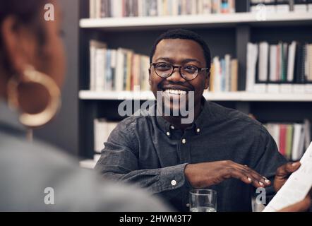 Our next project is going to be big. Cropped shot of a handsome young male architect having a discussion with his colleague in a modern office. Stock Photo