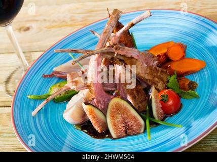 Roasted mutton ribs with figs, vegetables, demi-glace and red wine Stock Photo