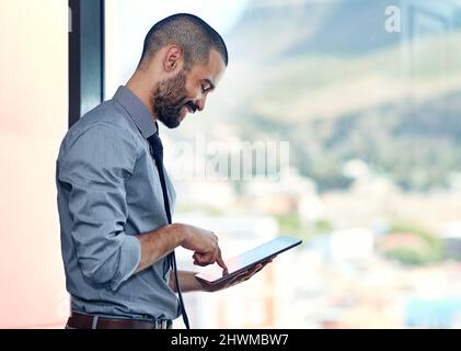 Hes a modern businessman. Cropped shot of a businessman using his tablet in the office. Stock Photo