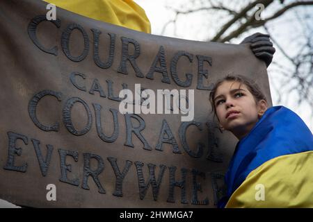 London, UK. 6th March 2022. A young protester stands next to the statue of suffragette Millicent Fawcett in Parliament Square where people have gathered to protest against Russia's invasion of the Ukraine and to call for an end of the war. Credit: Kiki Streitberger/Alamy Live News Stock Photo