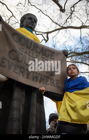 London, UK. 6th March 2022. A young protester stands next to the statue of suffragette Millicent Fawcett in Parliament Square where people have gathered to protest against Russia's invasion of the Ukraine and to call for an end of the war. Credit: Kiki Streitberger/Alamy Live News Stock Photo