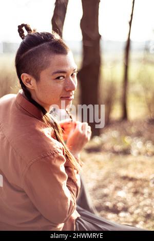 androgynous mixed race woman with freckles plats hair outside Stock Photo