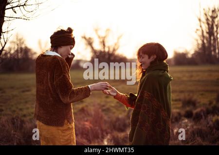 female friends share tea in golden hour afternoon sun outdoors Stock Photo