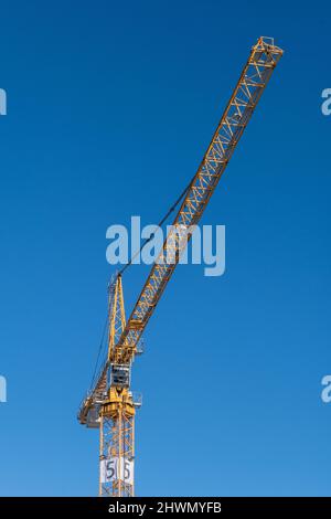 Helsinki / Finland - FEBRUARY 26, 2022: A tall construction crane standing against a bright blue sky Stock Photo