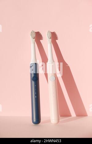 Two new modern ultrasonic toothbrushes. Dental care supplies on pink pastel background. Oral hygiene, dental and gum health, healthy teeth. Dental Stock Photo