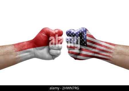Two hands punch to each others on white background. Country flags painted fists, conflict crisis concept between indonesia and usa Stock Photo