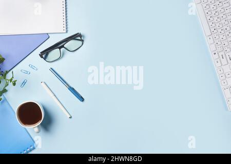 Bright office workspace. Work space with notepad, keyboard, coffee and glasses. Work space table desk. Flat lay, top view, copy space Stock Photo