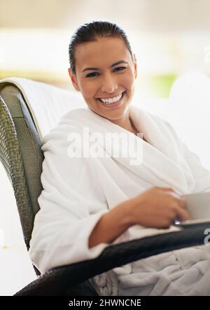 Enjoying some coffee between beauty treatments. Shot of a young woman drinking a cup of coffee at the day spa. Stock Photo