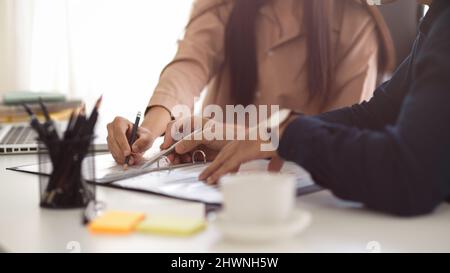 Close-up, cropped image, Male boss explaining and having meeting with his female financial assistant Stock Photo