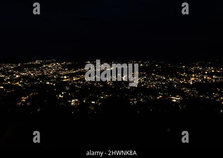 downtown city night view with lighting with dark black background from mountain top image is taken at evening shillong meghalaya india. Stock Photo