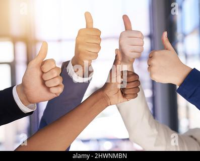 Were cheering you on. Shot of a group of hands showing thumbs up. Stock Photo