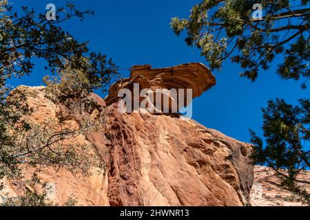 Looking Up to a Large Rock Balancing on the Edge of Cliff Stock Photo