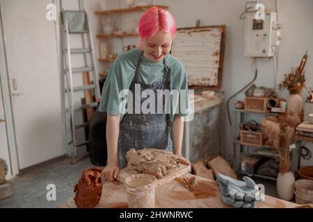 Young ceramist working with clay in workroom Stock Photo