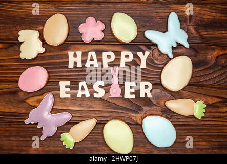 Beautiful coloured glazed Easter cookies on dark brown wooden table. Stock Photo