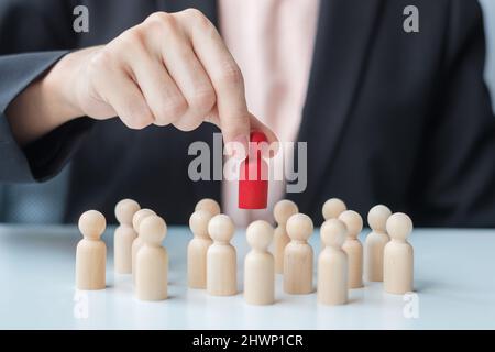 Businesswoman hand pulling leader man wooden from crowd of employees. Toxic People, Human resource management, Recruitment, Teamwork and leadership Co Stock Photo