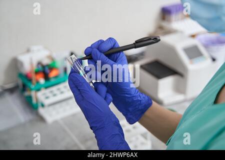 Woman making notes on flasks in the laboratory Stock Photo