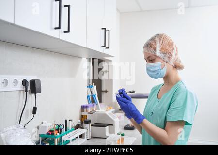 Doctor making notes on flasks in the laboratory Stock Photo