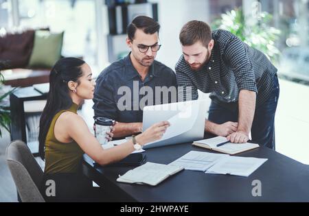 Putting their heads together as innovators. Shot of a group of young designers having a discussion in an office. Stock Photo