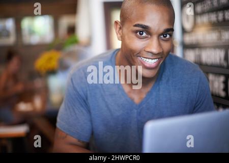 This cafe has free wifi. Cropped shot of a handsome young man using his laptop in a coffee shop. Stock Photo