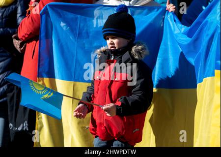 Riga, Latvia - March 05, 2022: Protest against war in Ukraine and Russia's invasion. Crowd of people with flags, signs and posters at demonstration Stock Photo
